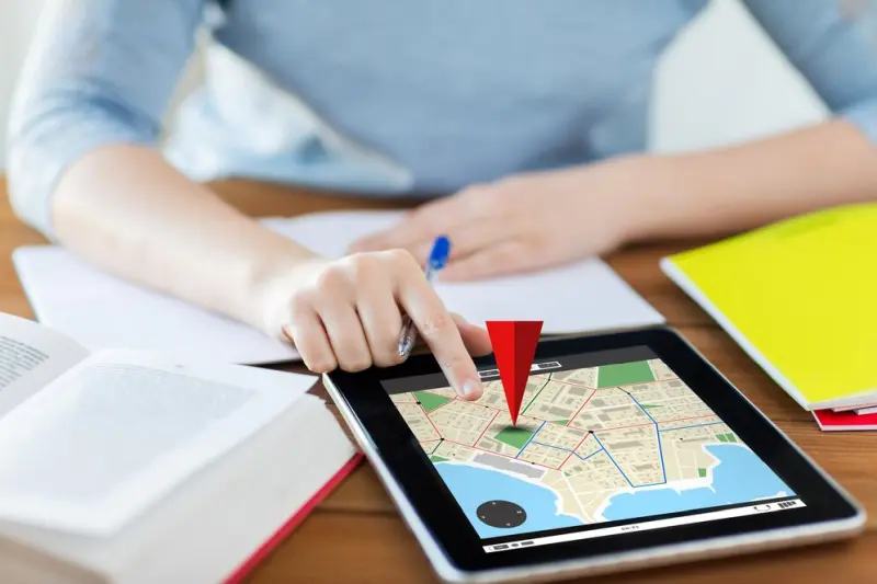 tablet map pin Finger taps red map pin on a tablet showing how our business directory helps users locate shops around town